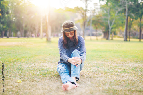 Sad woman sit down in field with sunlight background. © stcom