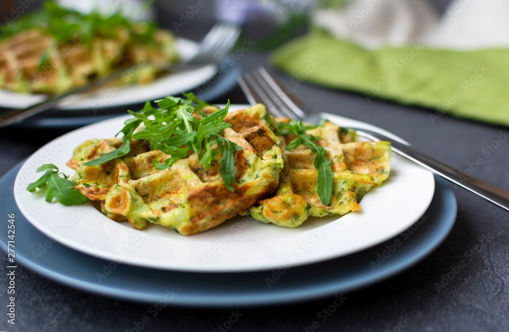 zucchini waffles with fresh arugula on white plate zucchini waffles with fresh arugula on white plate