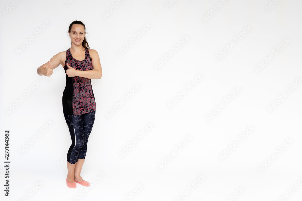 Full-length portrait on white background of beautiful pretty fitness woman girl in fashionable sportswear standing exercising in different poses, showing hands. Smiles Stylish trendy youth. Full-length portrait on white background of beautiful pretty fitness woman girl in fashionable sportswear standing exercising in different poses, showing hands. Smiles Stylish trendy youth.