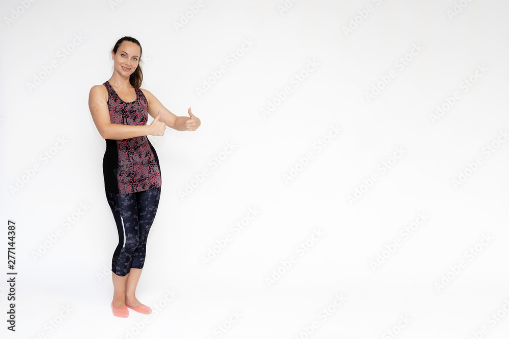 Full-length portrait on white background of beautiful pretty fitness woman girl in fashionable sportswear standing exercising in different poses, showing hands. Smiles Stylish trendy youth. Full-length portrait on white background of beautiful pretty fitness woman girl in fashionable sportswear standing exercising in different poses, showing hands. Smiles Stylish trendy youth.