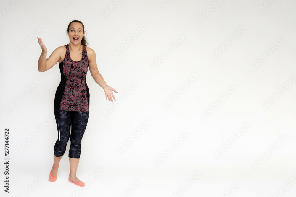 Full-length portrait on white background of beautiful pretty fitness woman girl in fashionable sportswear standing exercising in different poses, showing hands. Smiles Stylish trendy youth. Full-length portrait on white background of beautiful pretty fitness woman girl in fashionable sportswear standing exercising in different poses, showing hands. Smiles Stylish trendy youth.