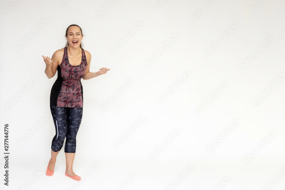 Full-length portrait on white background of beautiful pretty fitness woman girl in fashionable sportswear standing exercising in different poses, showing hands. Smiles Stylish trendy youth. Full-length portrait on white background of beautiful pretty fitness woman girl in fashionable sportswear standing exercising in different poses, showing hands. Smiles Stylish trendy youth.