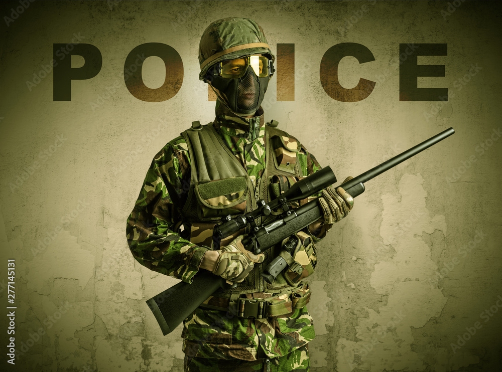 Uniformed armed soldier with damaged wall background Uniformed armed soldier with damaged wall background