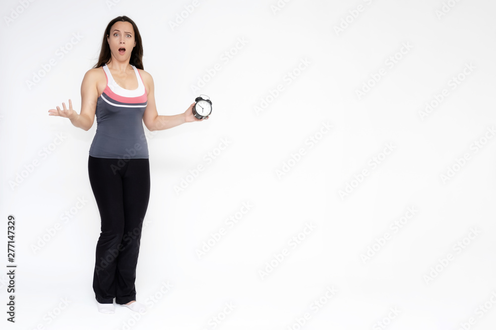 Full-length portrait on white background of beautiful pretty fitness girl woman in sports uniform with a clock in her hands, stands with different emotions in different poses. Stylish trendy youth.