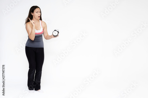 Full-length portrait on white background of beautiful pretty fitness girl woman in sports uniform with a clock in her hands, stands with different emotions in different poses. Stylish trendy youth.