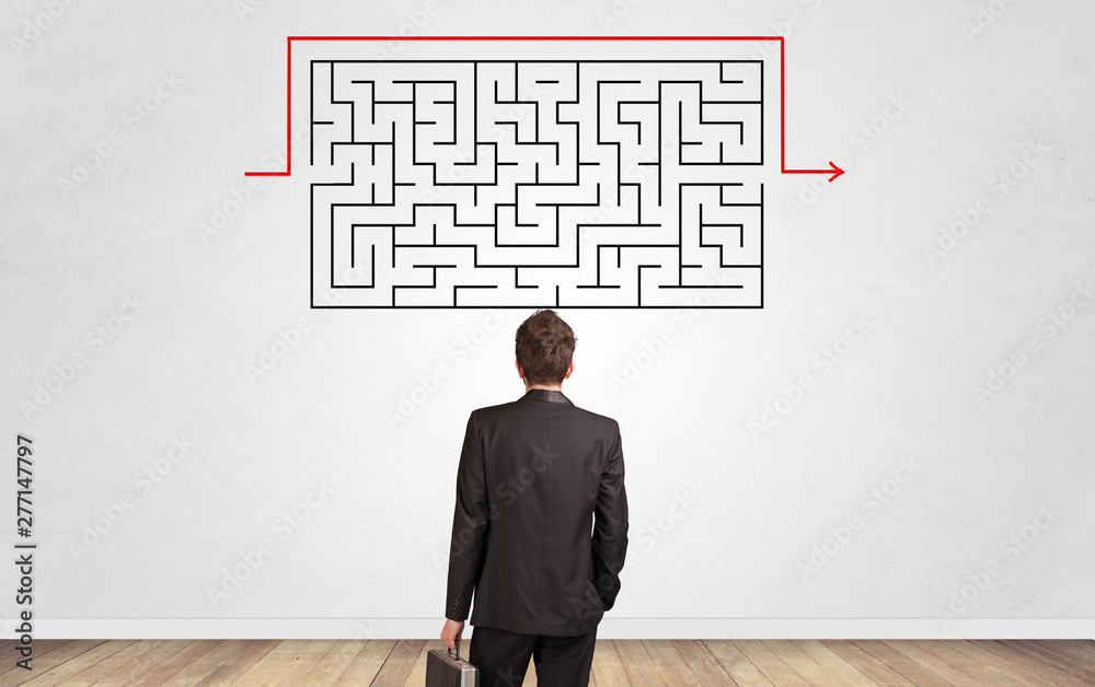 Businessman in doubt looking to a maze and searching the way out Businessman in doubt looking to a maze and searching the way out