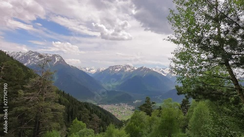 Wallpaper Mural Fast motion video. Fluffy cumulus cloud quickly flying across sky. Mountain peaks in snow. Cozy valley located mountain village. Hillside covered with pine forest. Cloudy weather Torontodigital.ca