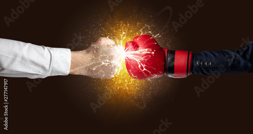 Two hands fighting with orange dust, spark, glow and smoke concept