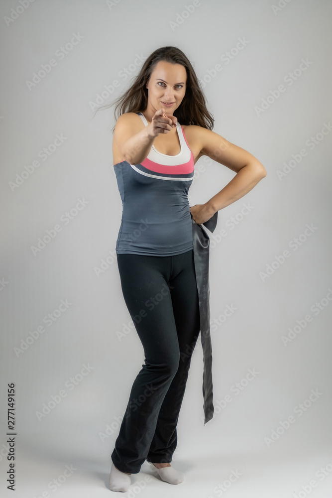Full-length portrait on white background of beautiful pretty fitness girl woman in sports uniform with rubber expander in hands, with different emotions in different poses. Stylish trendy youth. Full-length portrait on white background of beautiful pretty fitness girl woman in sports uniform with rubber expander in hands, with different emotions in different poses. Stylish trendy youth.