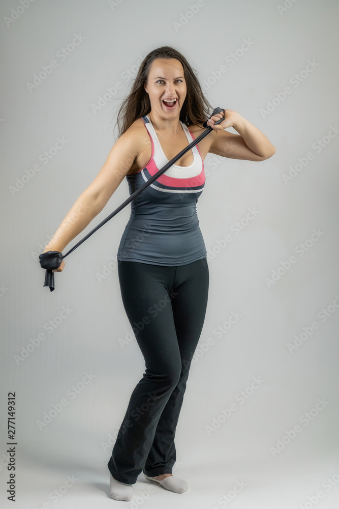 Full-length portrait on white background of beautiful pretty fitness girl woman in sports uniform with rubber expander in hands, with different emotions in different poses. Stylish trendy youth.