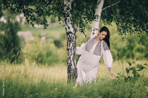 teenager in an embroidered dress in nature