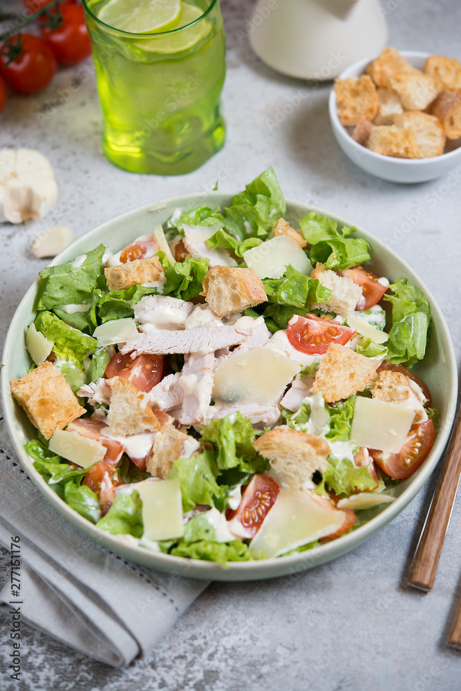 Caesar salad with chicken, Parmesan and wheat croutons on a vintage grey background. Light diet dinner. Caesar salad with chicken, Parmesan and wheat croutons on a vintage grey background. Light diet dinner.