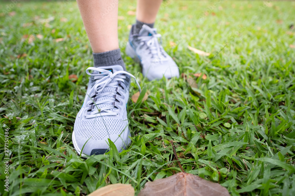 Female jogging in Central Park by wearing sports shoes exercise in the evening sunset Female jogging in Central Park by wearing sports shoes exercise in the evening sunset