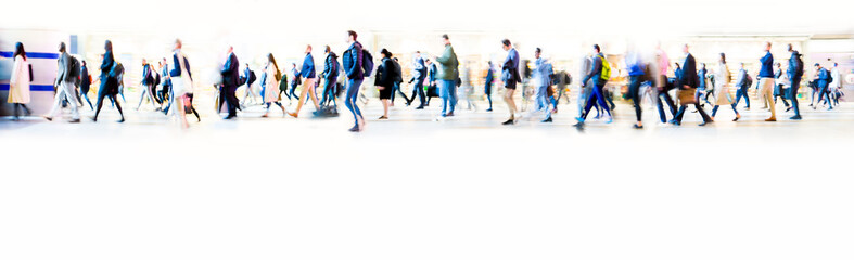 Beautiful motion blur of walking people in train station. Early morning rush hours, busy modern life concept. Ideal for websites and magazines layouts