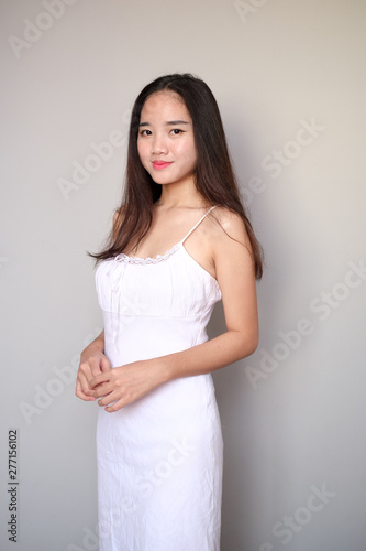 Asian girl with nice outfit  wearing a long plain sleeveless dress.