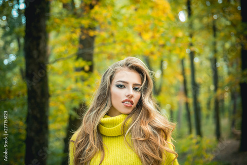 Beautiful Woman with Autumn Leaves on Fall Nature Background. Outdoor portrait Gorgeous brunette model girl with sunny day light. Fashion photo of young beautiful lady surrounded autumn leaves.