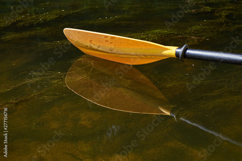Yellow paddle close up.Yellow paddle over the water.