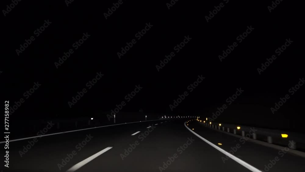 4K, POV view of car driving on road of highway at night in Spain. Drive on an empty road in the dark evening. A car drives on a freeway. Asphalt with white line at new road.-Dan