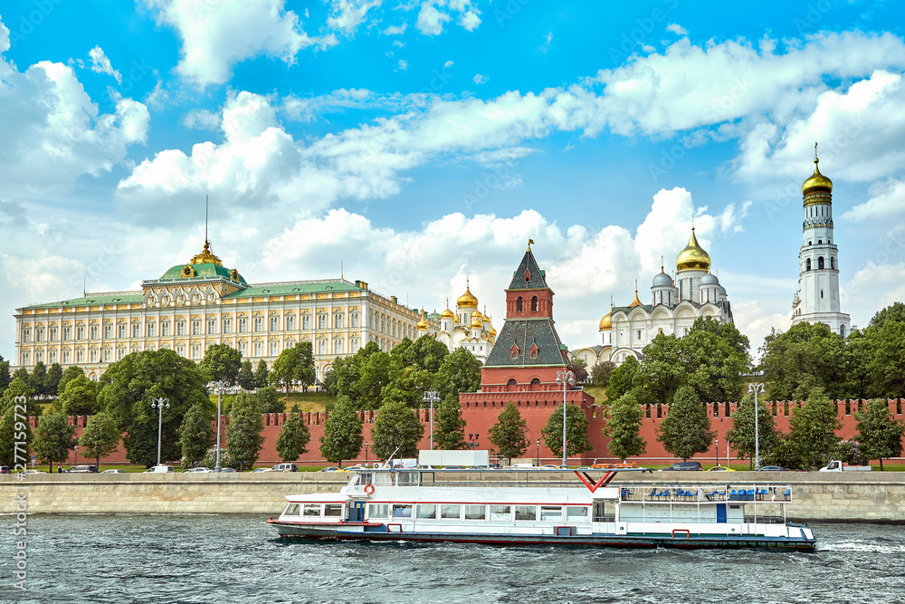 A modern river ship in the center of Moscow sails past the Kremlin. Picturesque modern urban architecture. Tourism, rest in the city, river transport.