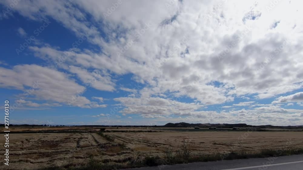 4K, view from a car driving on road through beautiful countryside of Spain. Drive on an empty road in a bright summer day with blue sky. Spanish landscape of the field.-Dan 4K, view from a car driving on road through beautiful countryside of Spain. Drive on an empty road in a bright summer day with blue sky. Spanish landscape of the field.-Dan