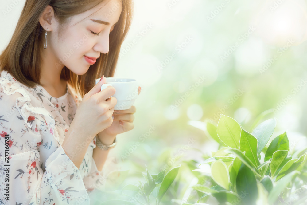 Portrait of young asian woman close her eyes and feel happiness when she drink coffee with green nature background. Closeup photo and soft focus Portrait of young asian woman close her eyes and feel happiness when she drink coffee with green nature background. Closeup photo and soft focus