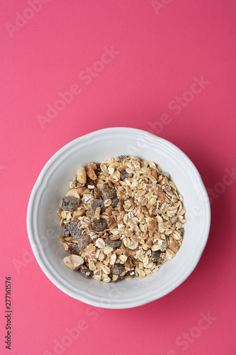 Cuadro en lienzo A plate of delicious muesli on a bright pink background, top view