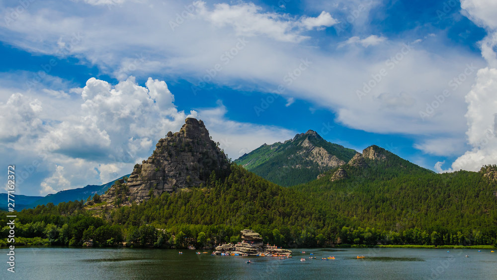 Beautiful mountain peak in clouds with rocks and pine forest Beautiful mountain peak in clouds with rocks and pine forest