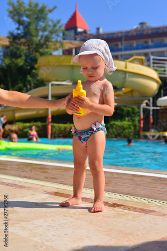 Mother putting sunscreen on a little girl