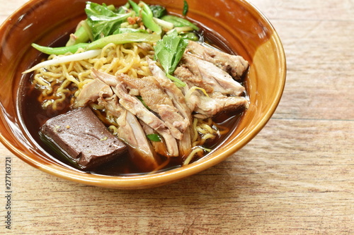 egg noodles with boiled duck in Chinese herb brown soup on bowl