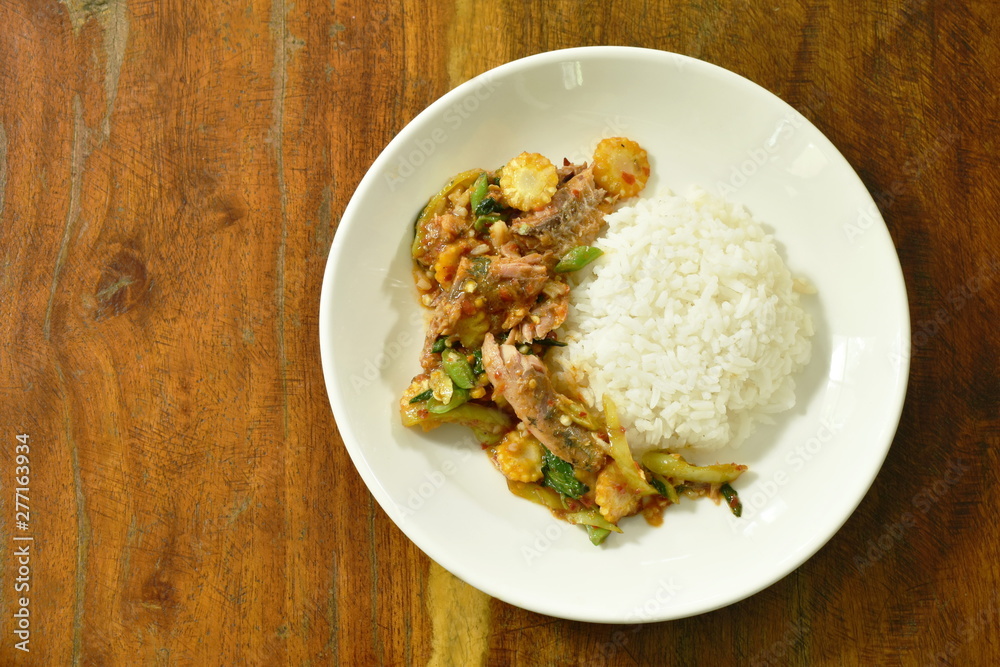 spicy stir fried canned sardines fish with chili and basil leaf on rice