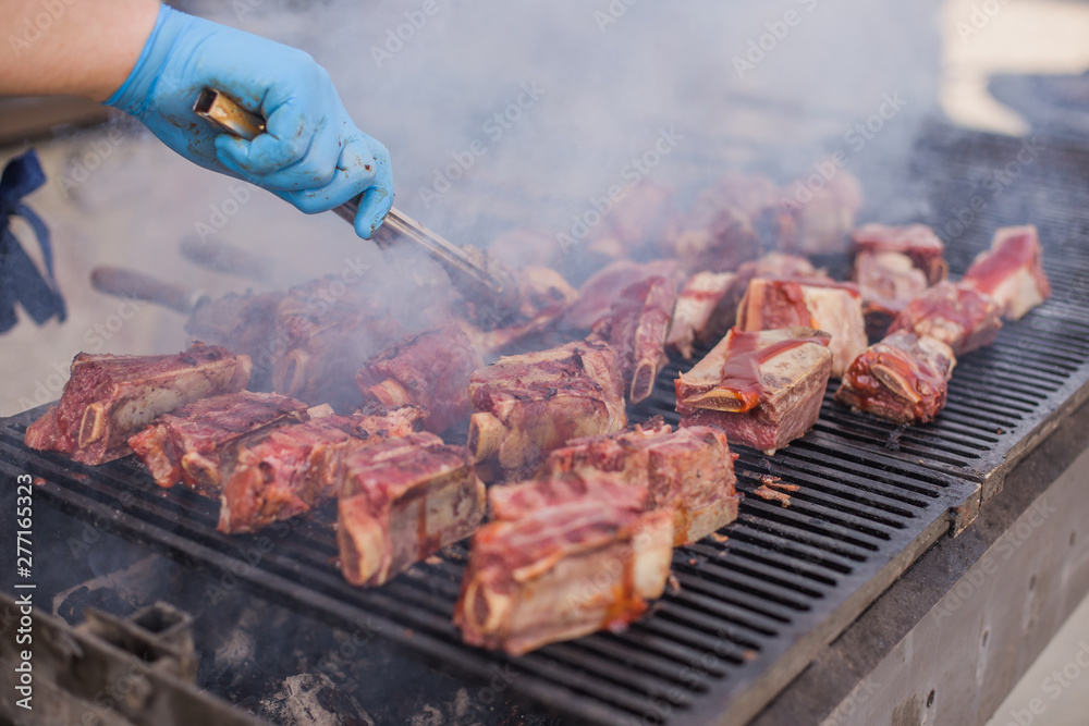 American BBQ, Frying Fresh Meat, Chicken Barbecue,Pork, Ribs, Kebab, Hamburger, Barbecue,Josper, Beef. Sunny outdoor.Chef turns the meat on the rotating Grill.