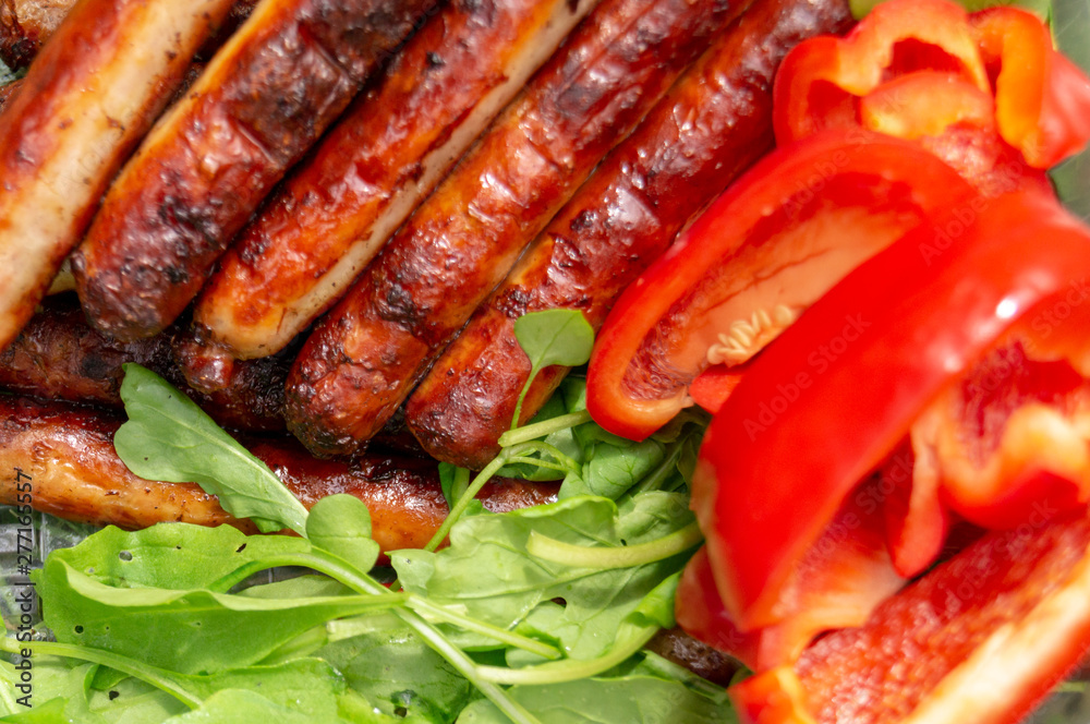 sausages are fried in the grill and arugula, red bell pepper sausages are fried in the grill and arugula, red bell pepper