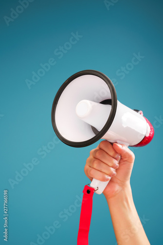 Image of hand with white mouthpiece on empty blue background