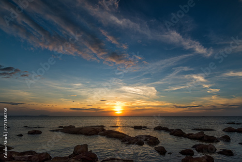 The rock on the sea with sunset sky