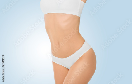 perfect slim female body, hips and belly on a blue background. Diet and weight loss