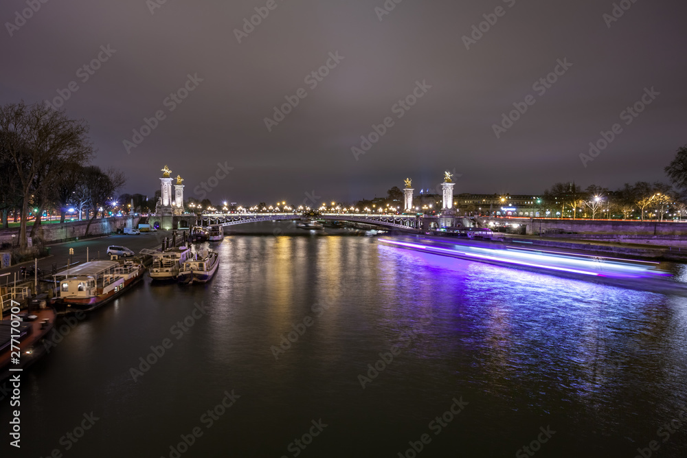 Pont Alexandre III in Paris at night. This bridge is one of the most beautiful and decorated bridges in the world and is located in the Invalides area.