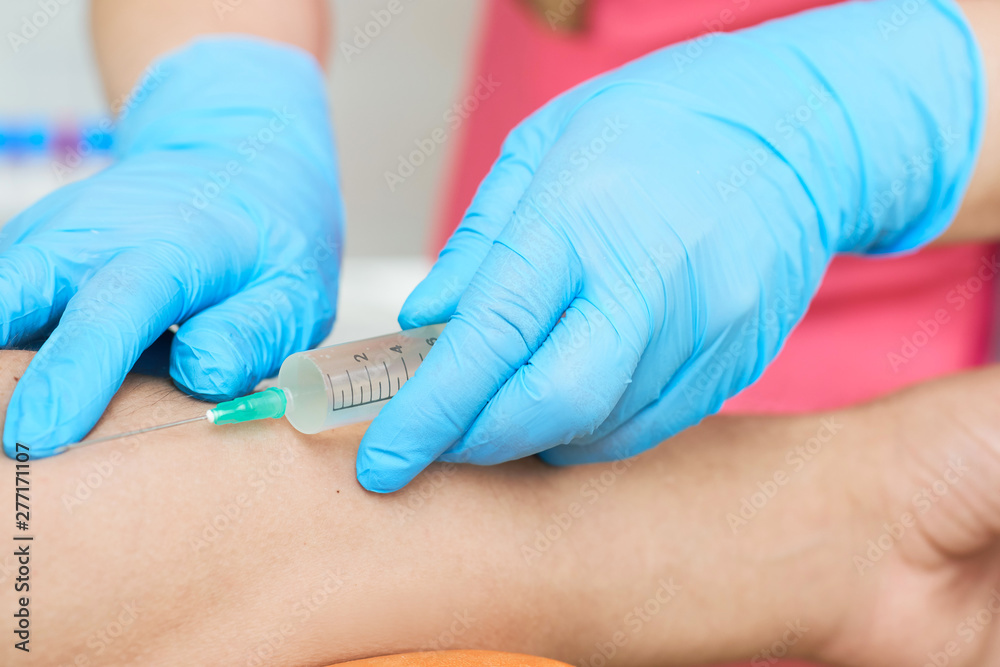 Nurse with a syringe in her hand is going to take a patient's blood sample for a blood test at the hospital. Nurse with a syringe in her hand is going to take a patient's blood sample for a blood test at the hospital.