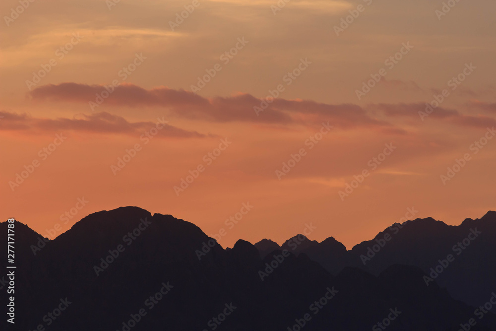 Sunset over the mountains. Orange sky