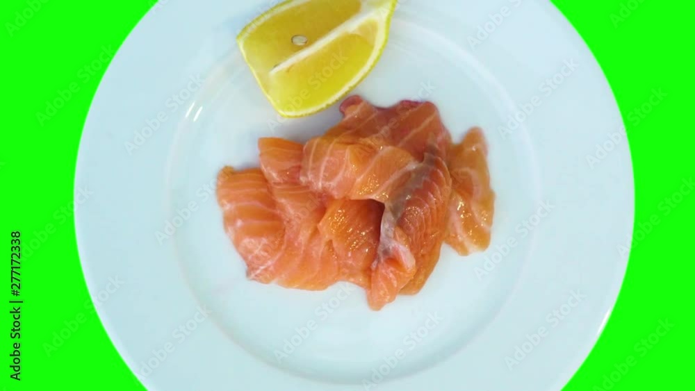Top view, raw salmon, slices and lemon on a plate. The plate rotates. Healthy food concept. Top view, raw salmon, slices and lemon on a plate. The plate rotates. Healthy food concept.