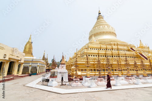 Buddhist monk walking next to Shwezigon Paya golden temple in Bagan  Myanmar