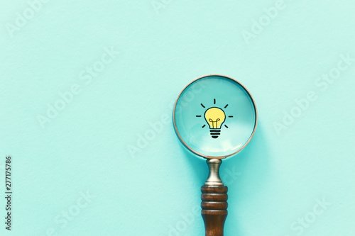 Business concept image. Magnifying glass and lamp. Finding the best idea and inspiration among others photo