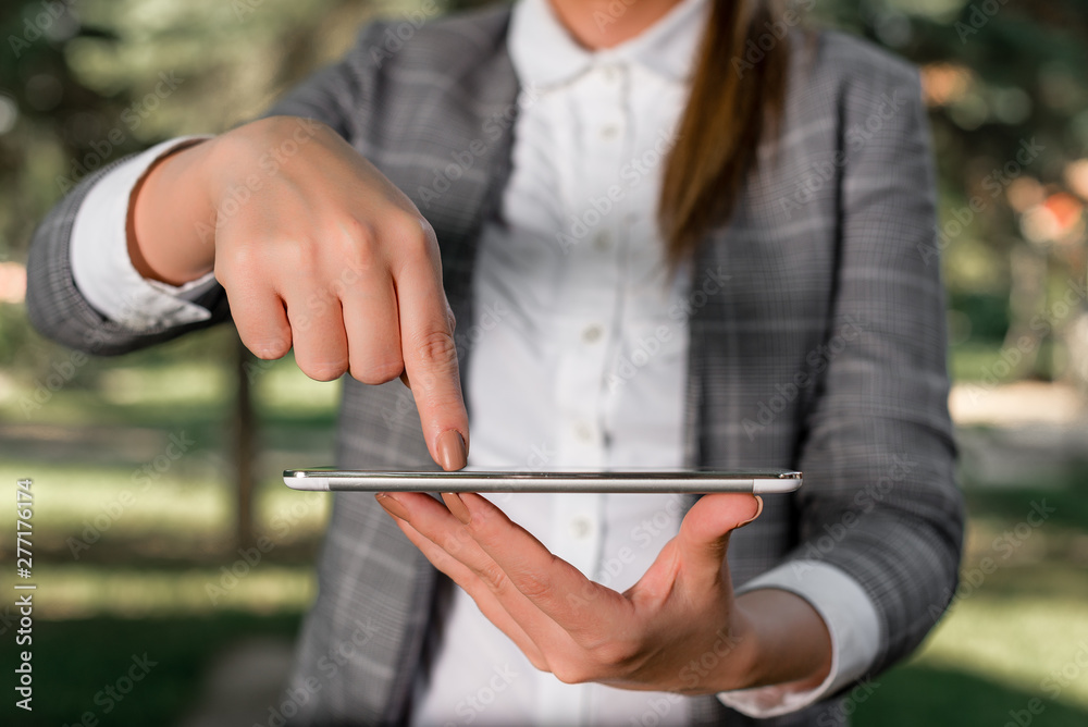 Outdoor scene with business woman holds lap top with touch screen.