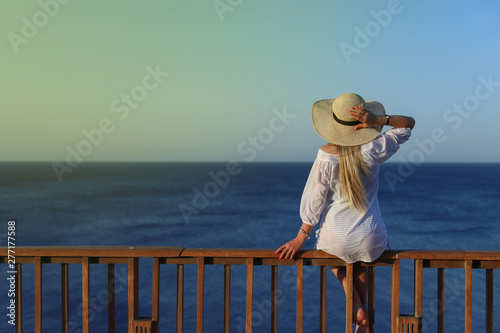 Outdoor summer portrait of young pretty woman looking to the sea