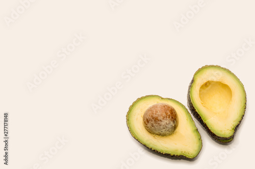 Ripe avocado cut in half on neutral background