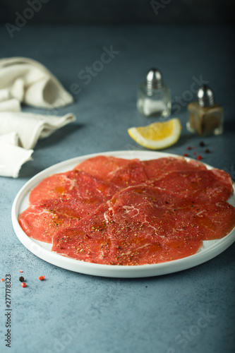 Homemade beef carpaccio with salt and pepper