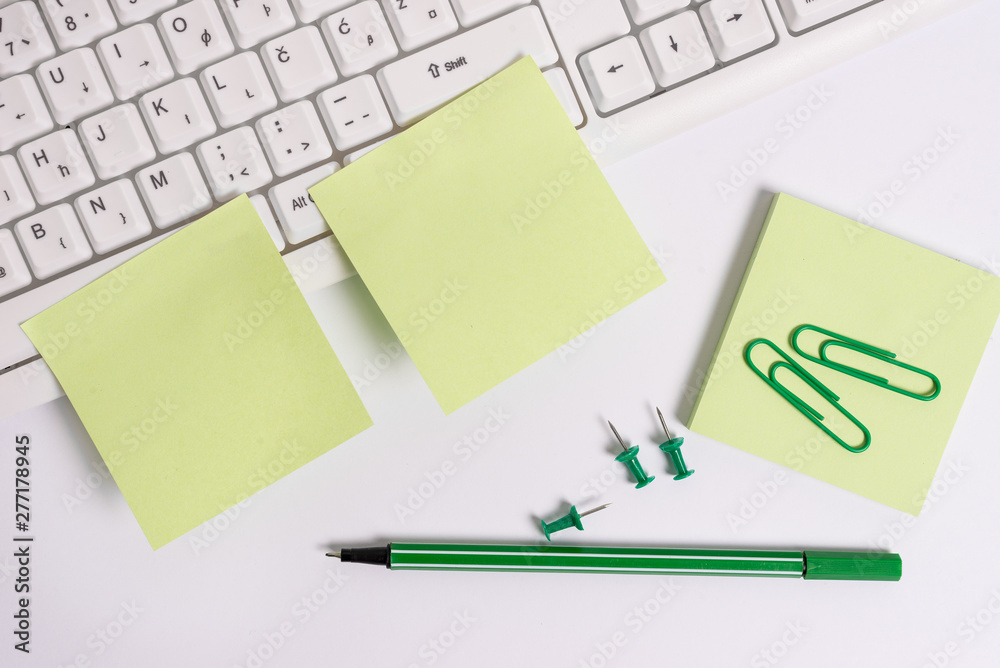 Empty green note paper and paper clips with pencil on the white background and pc keyboard. Empty green note paper and paper clips with pencil on the white background and pc keyboard.