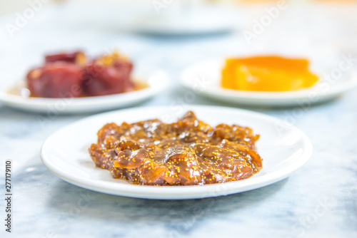 Sweet delicious and tasty fig jam or fig marmalade dessert in plate on white table background. Various fruit desserts or jams 
