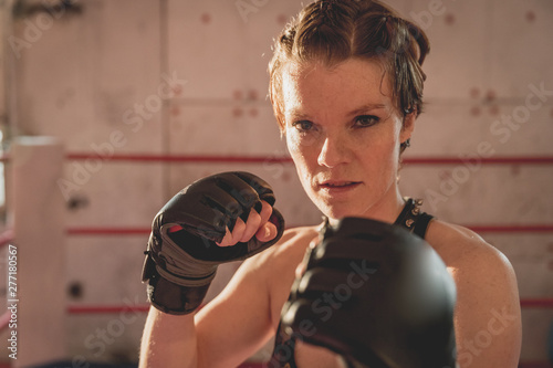 Gorgeous woman, mma fighter in gym during training. Preparing for a hard caged match