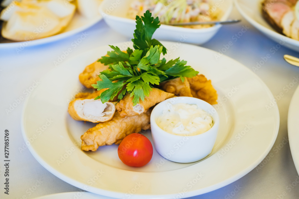 food in a plate on the festive table. table setting at the banquet. cold appetizer and salad for business lunch close up