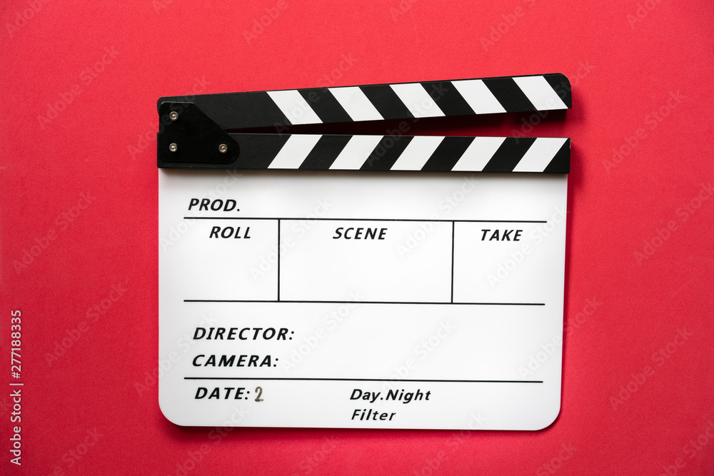 Obraz premium movie clapper on red table background ; film, cinema and video photography concept
